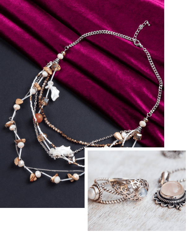 A layered necklace with beads and charms is displayed on dark red fabric. Inset shows two ornate silver rings with gemstones on a light surface.